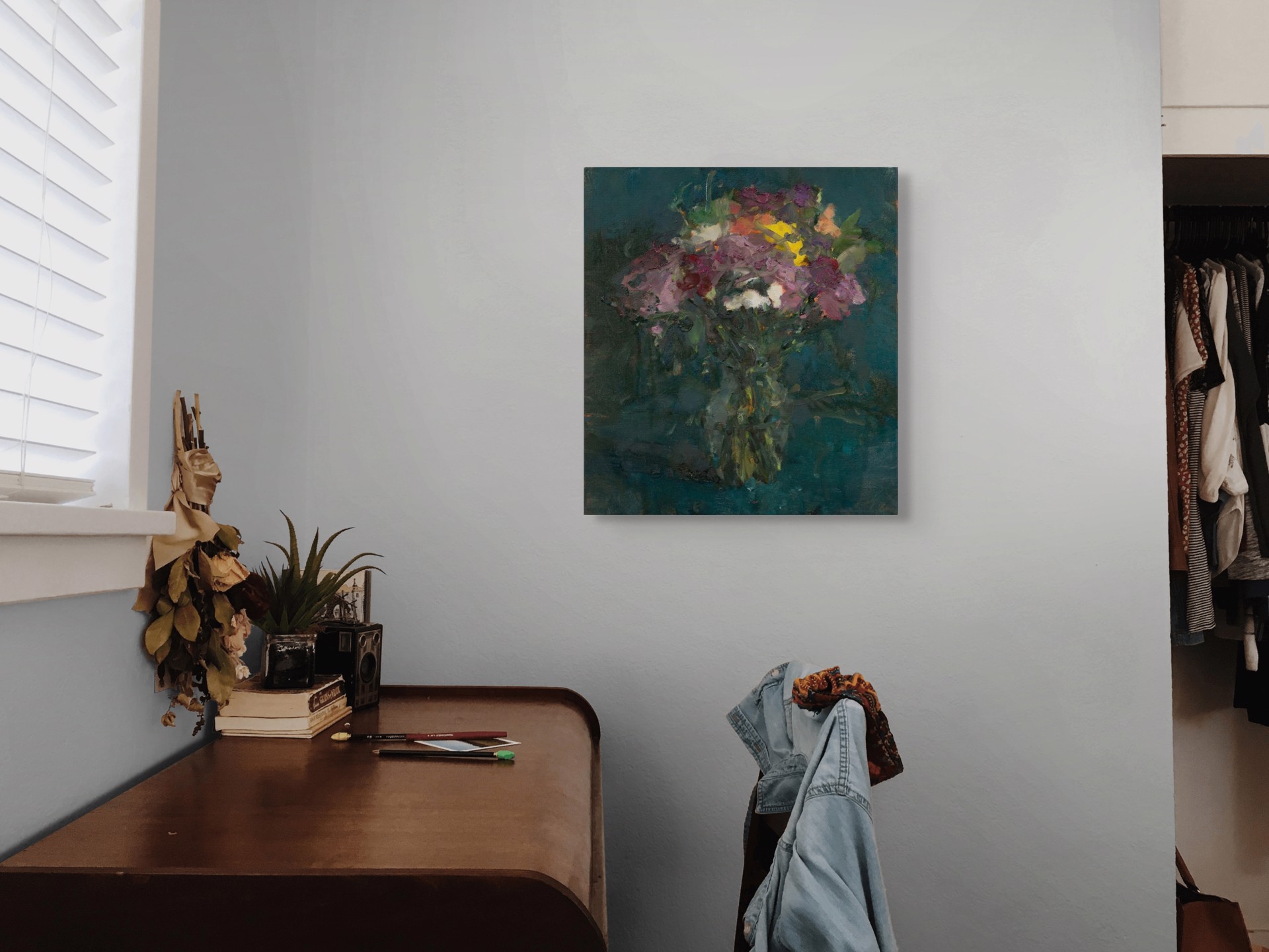 A vibrant bouquet of flowers in a vase against a dark teal background.