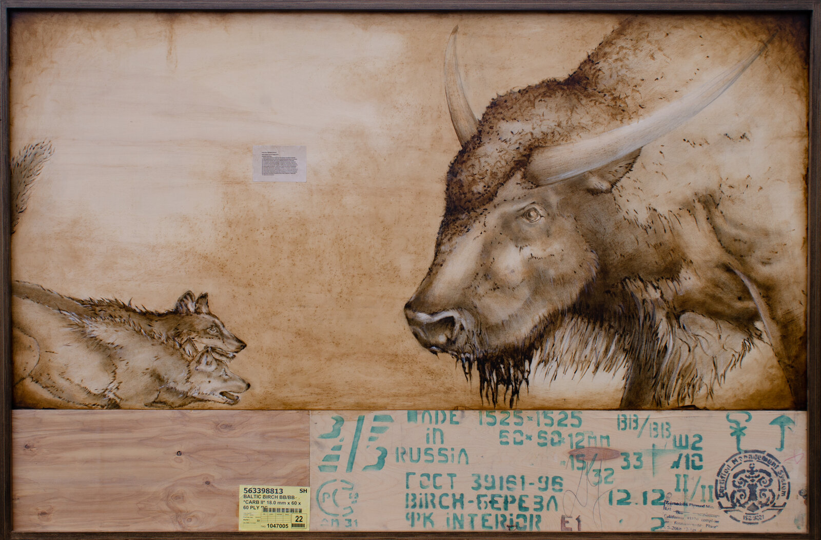 A woodburning artwork featuring a large bull and two wolves on a raw plywood surface.