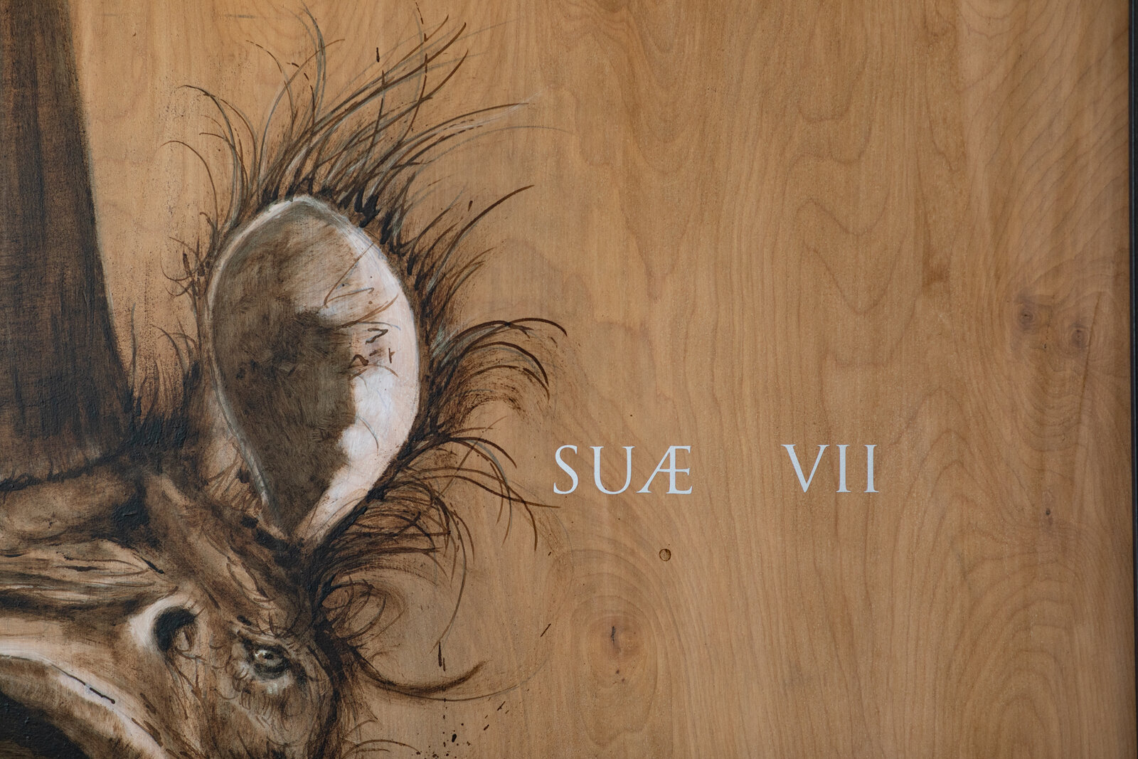 A hyper-realistic charcoal sketch of a rhinoceros head on a wood-grain background with white text.
