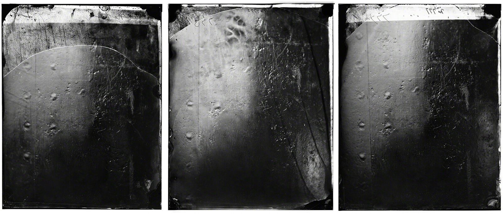 A triptych of black and white photographic plates showing textured surfaces with visible imperfections.
