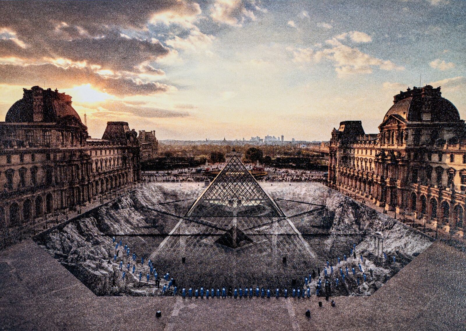 A group of people standing in front of a pyramid.