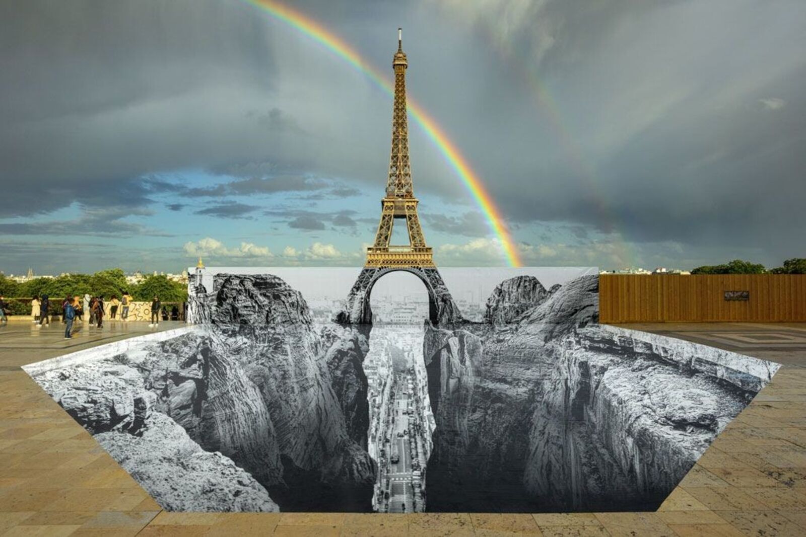 A composite of four surreal street art installations featuring a towering tower over a black-and-white chasm.