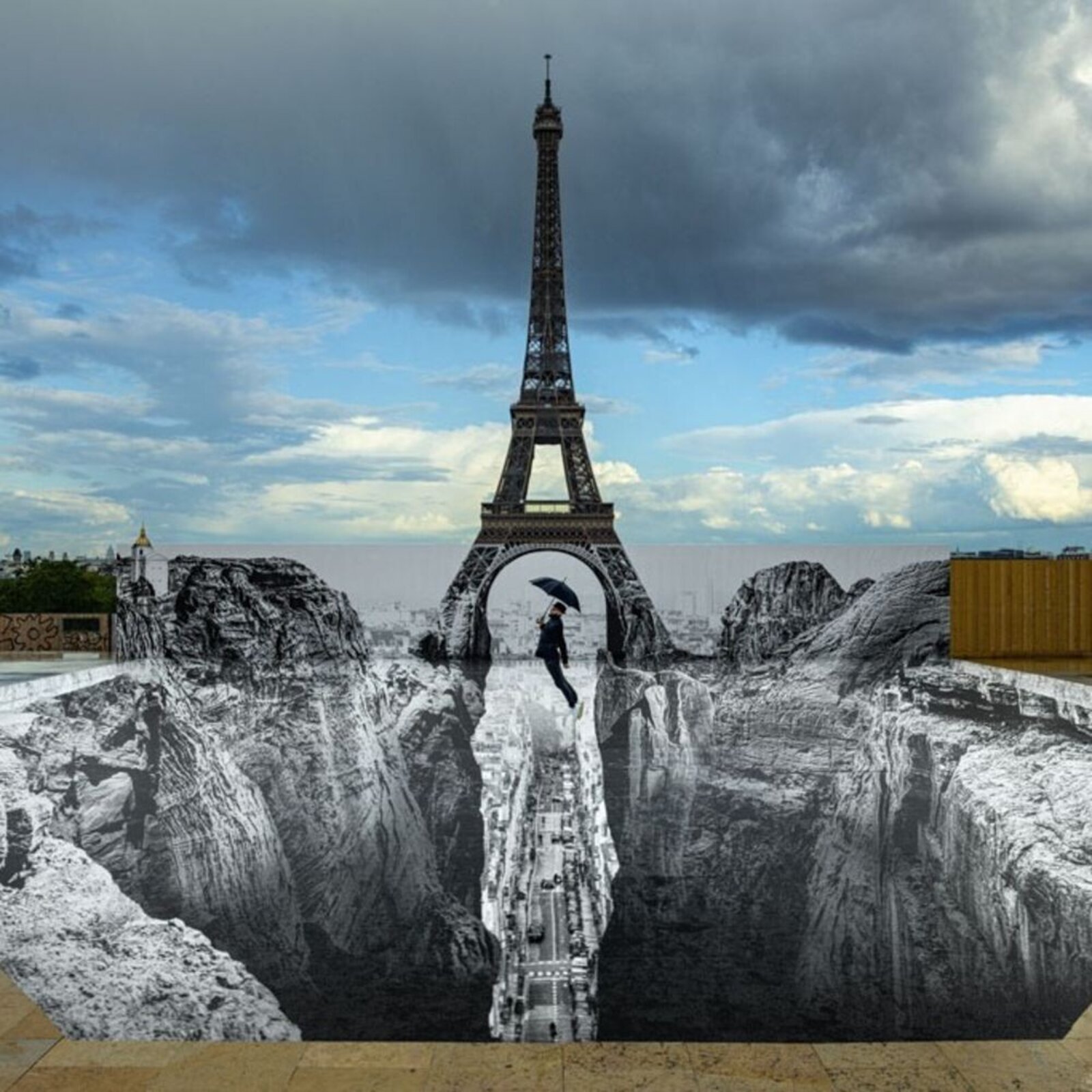 A surreal 3D illusion of a person falling into a deep pit beneath the Eiffel Tower.