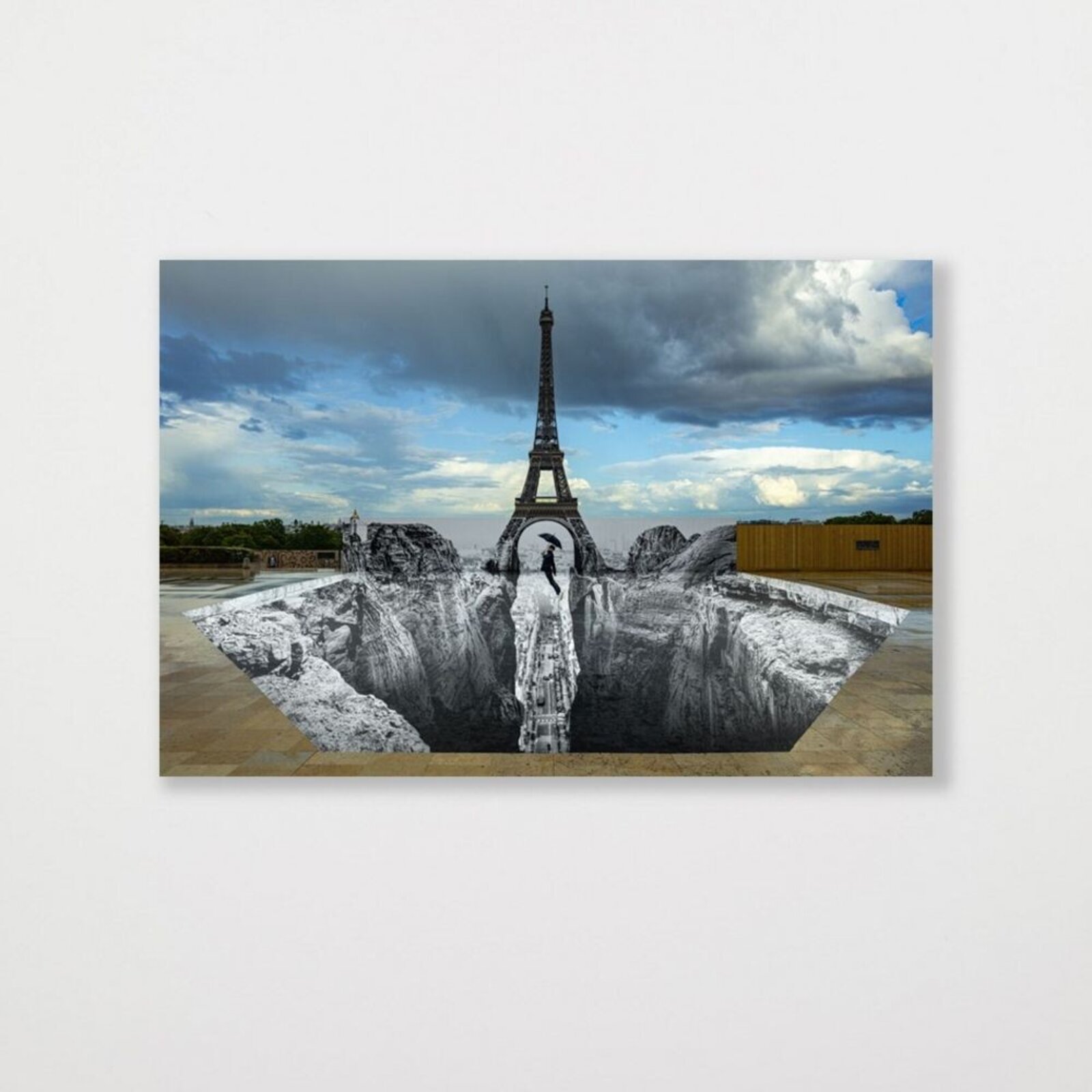 A surreal 3D illusion of a person falling into a deep pit beneath the Eiffel Tower.