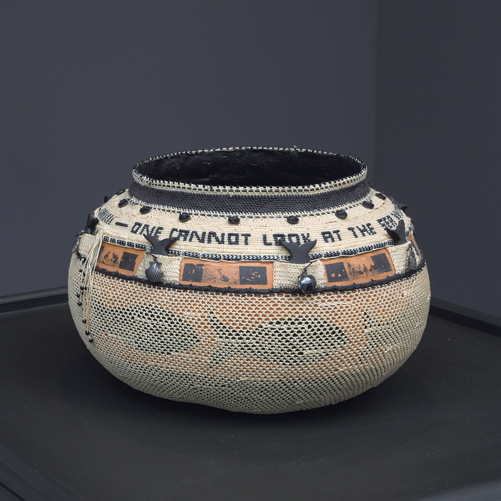 A woven basket with intricate black and orange decorative bands.