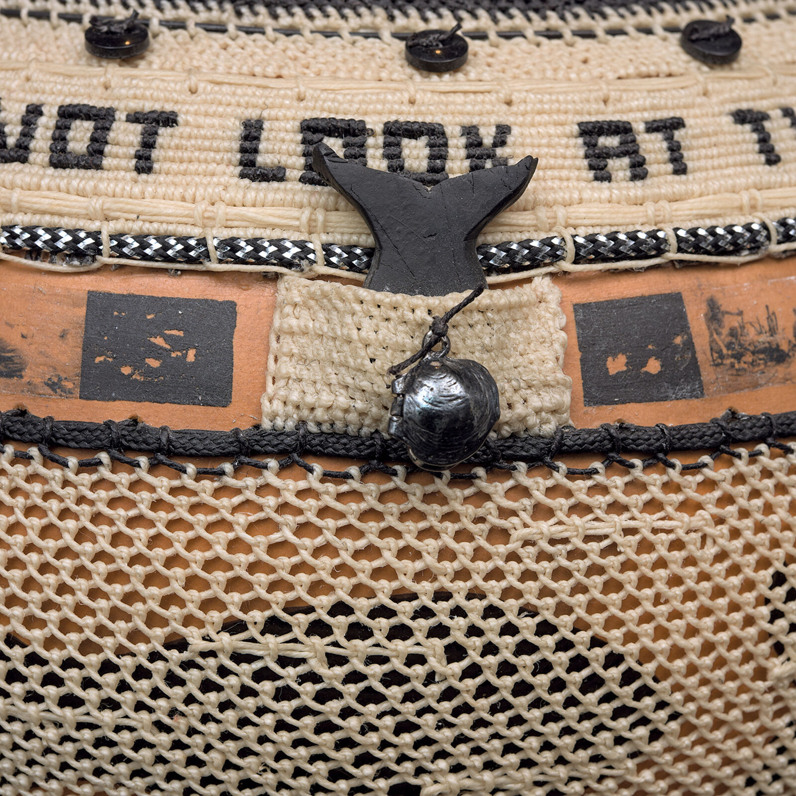 A woven basket with intricate black and orange decorative bands.