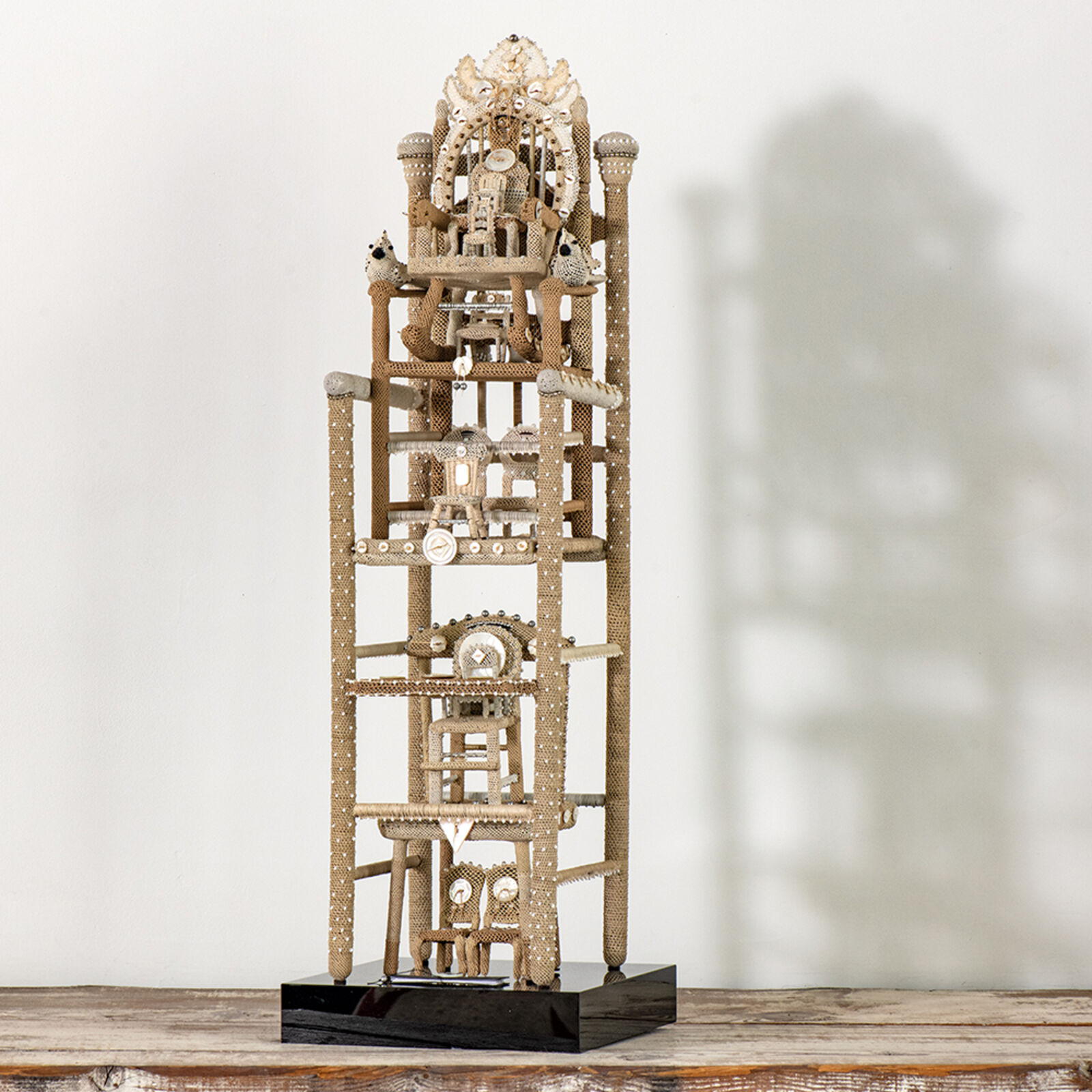 A multi-tiered sculpture resembling a miniature tower or clockwork structure.