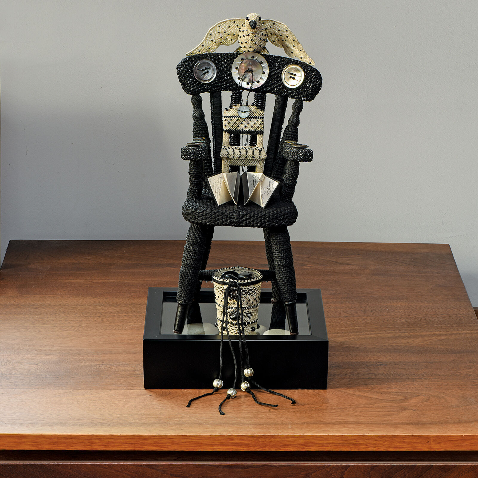 A sculpture of a chair on a wooden table.