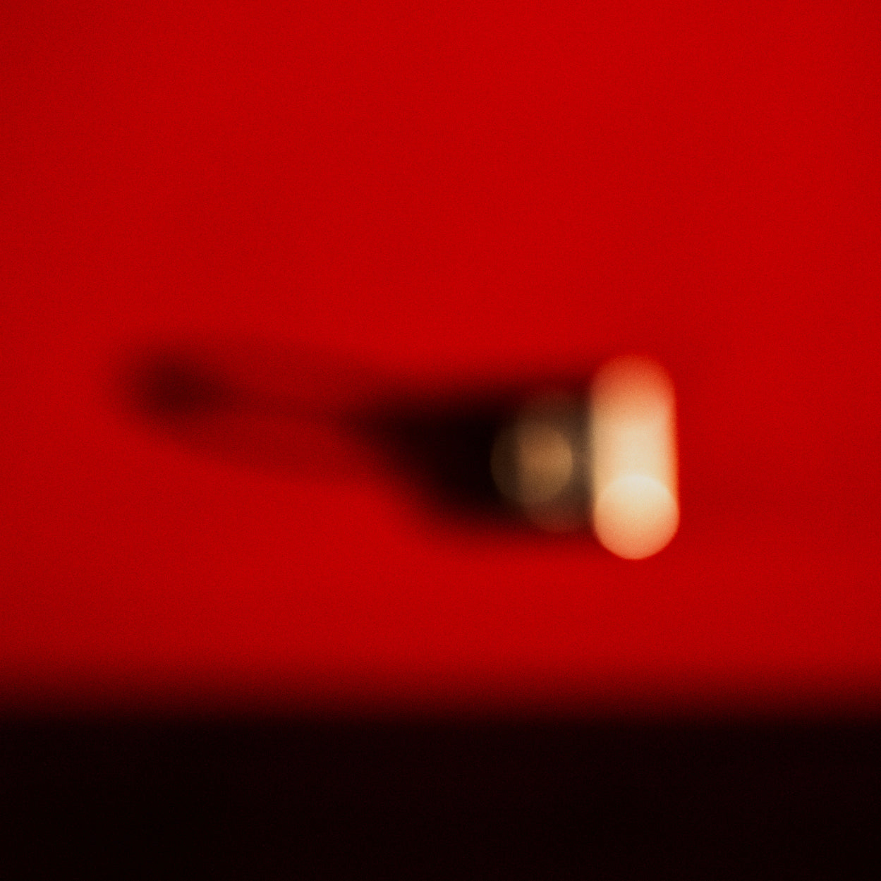 A blurry image of a person's shadow on a red background.