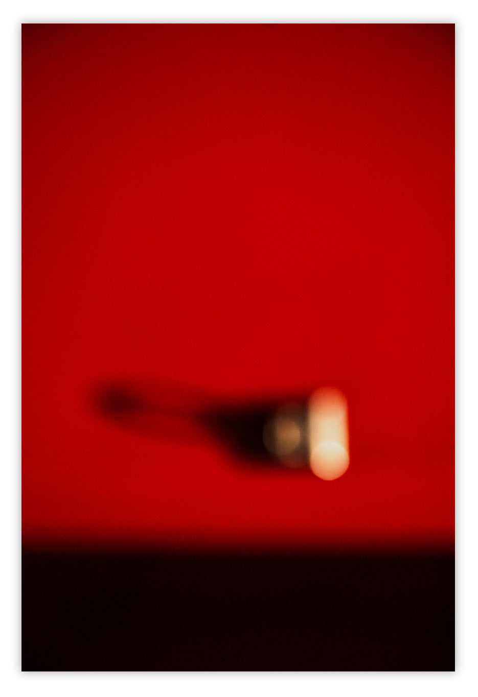 A blurry image of a person's shadow on a red background.