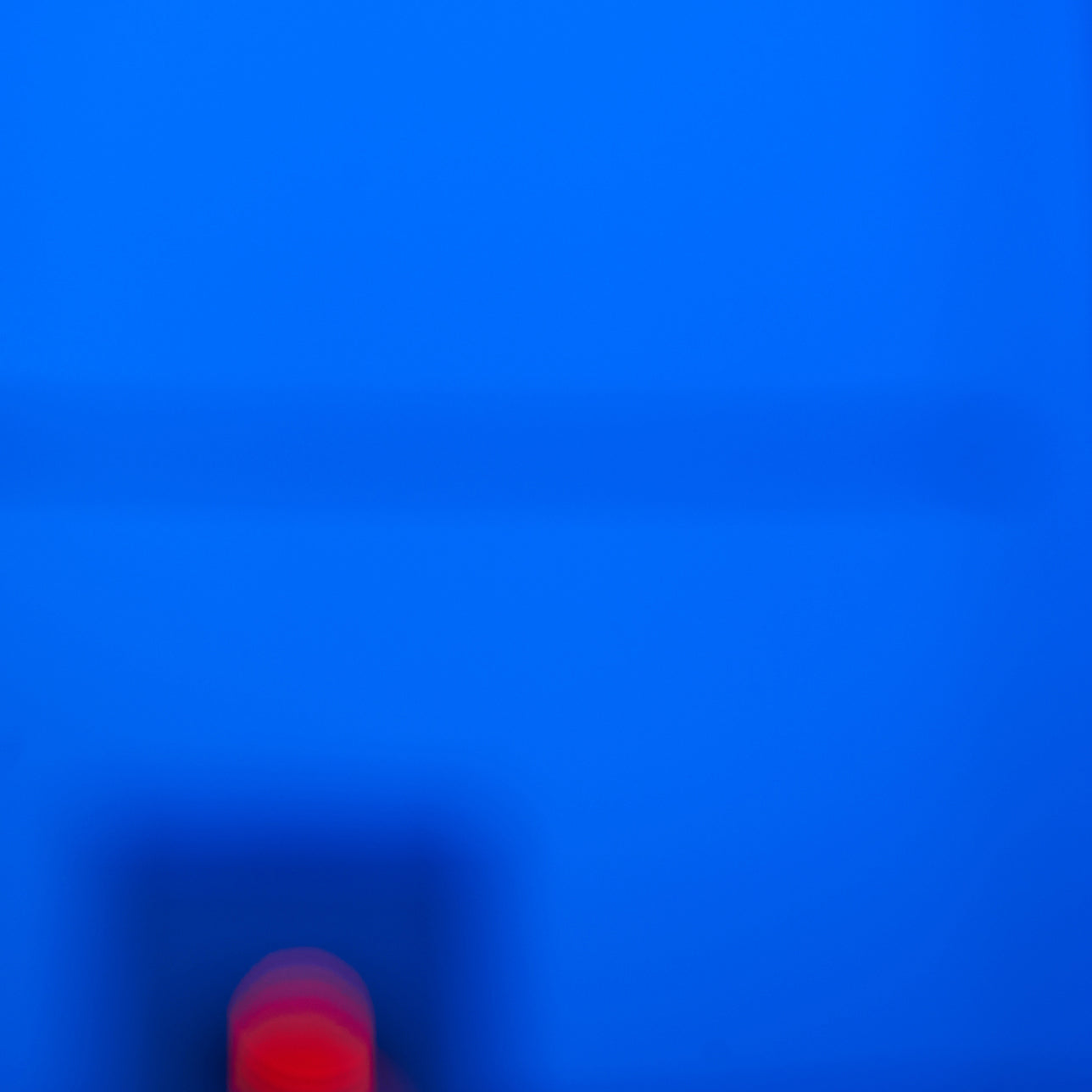 A blurry image of a red ball in the middle of a blue background.