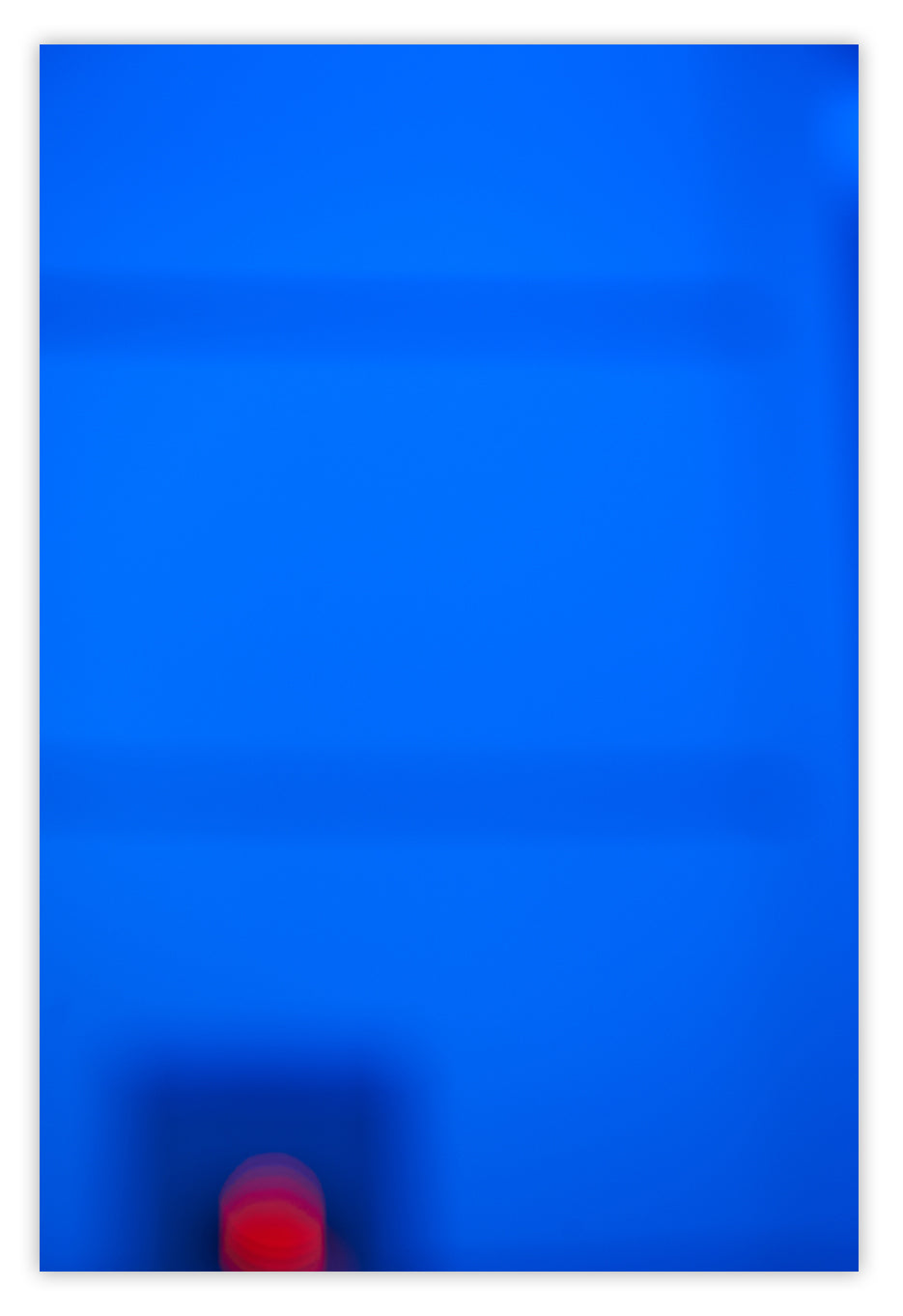 A blurry image of a red ball in the middle of a blue background.