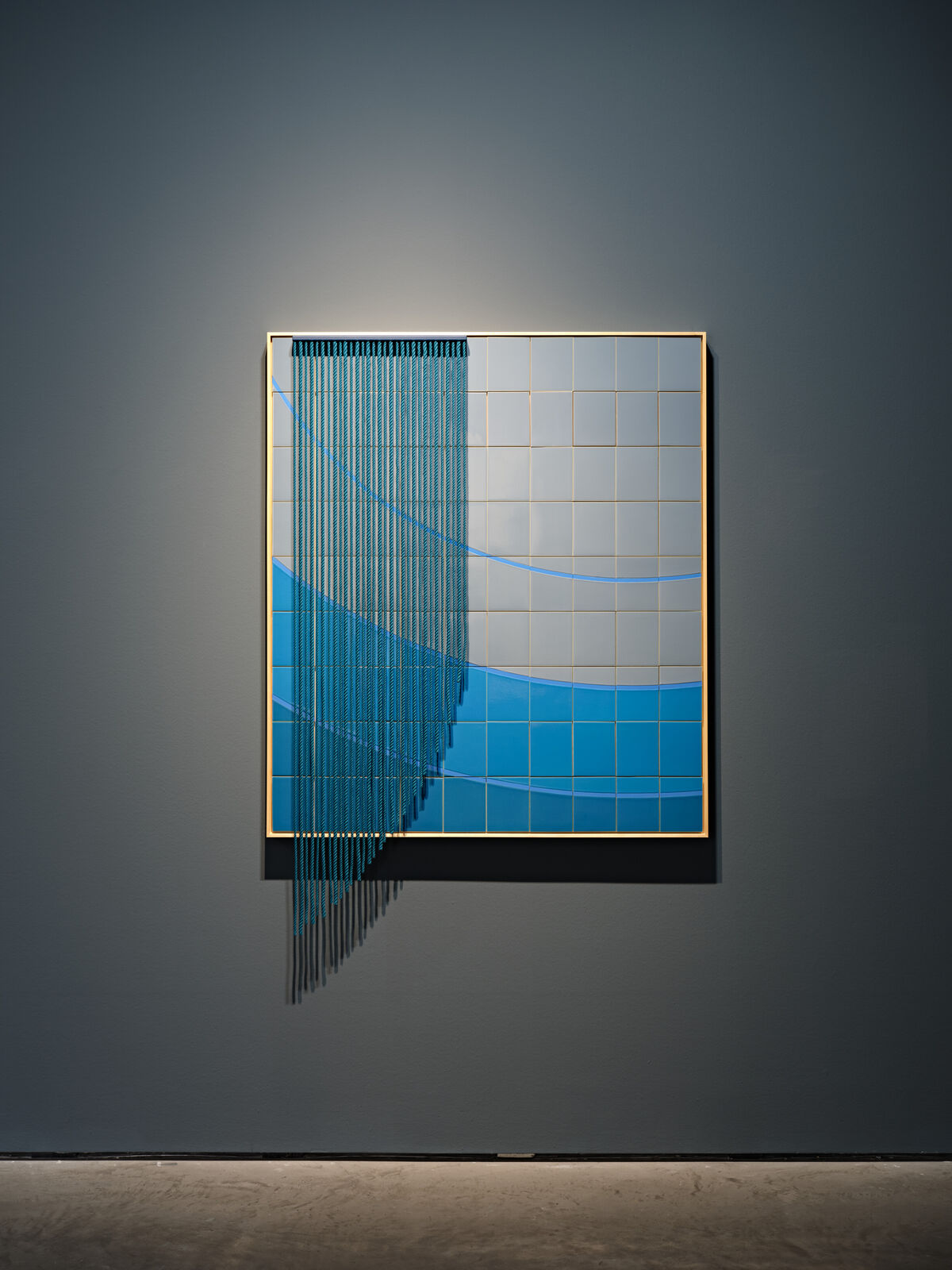 A blue and white painting hanging on a wall in a room.