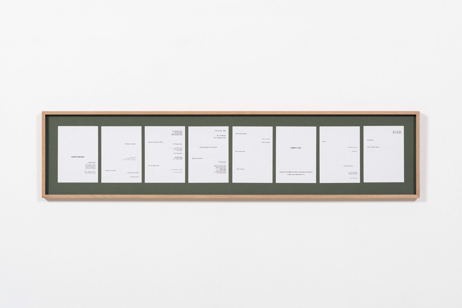 A picture frame with a bunch of cards hanging on a wall.