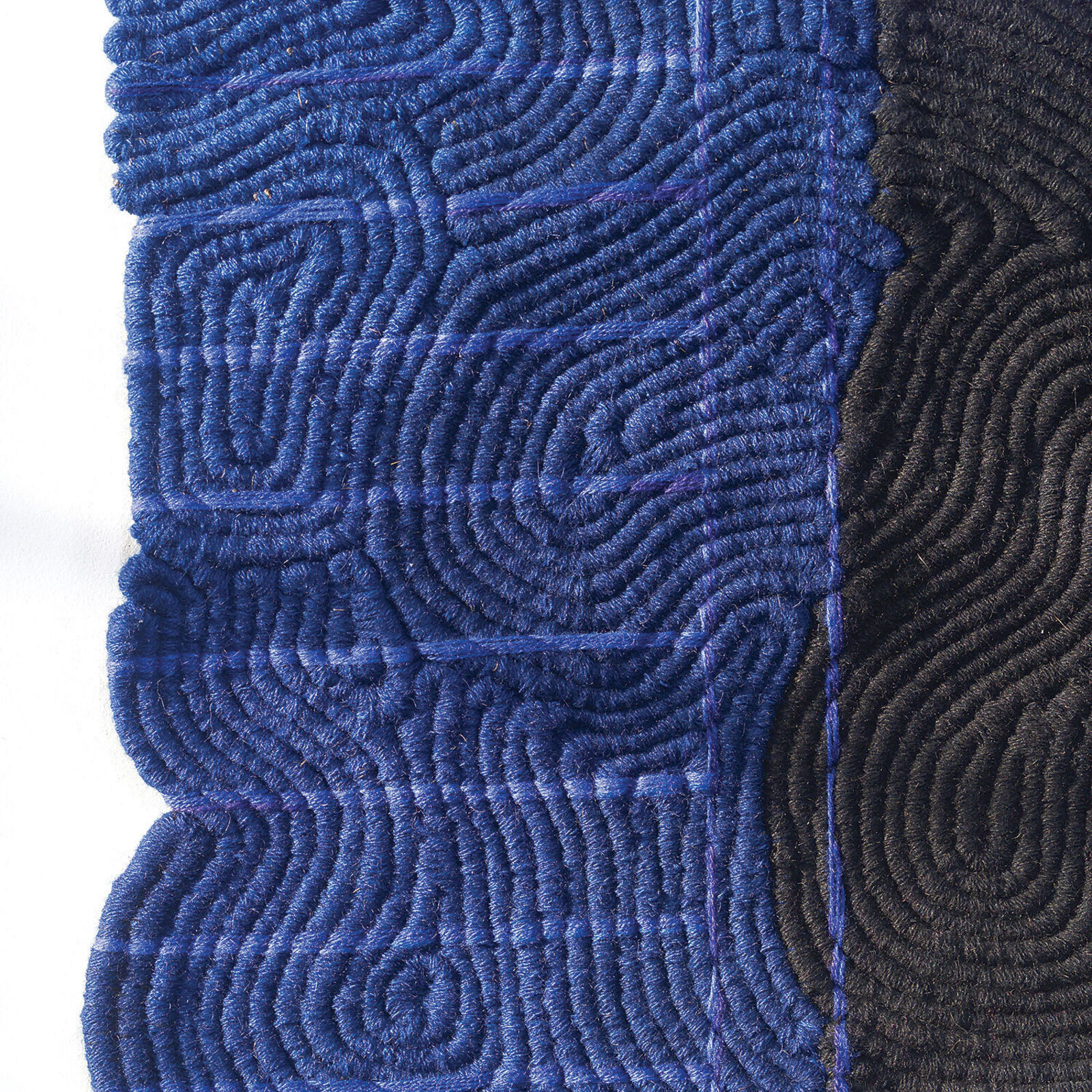 A black and blue blanket hanging on a wall in a room.