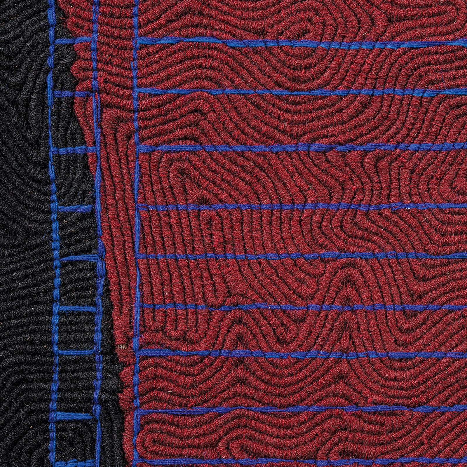 A black and blue blanket hanging on a wall in a room.