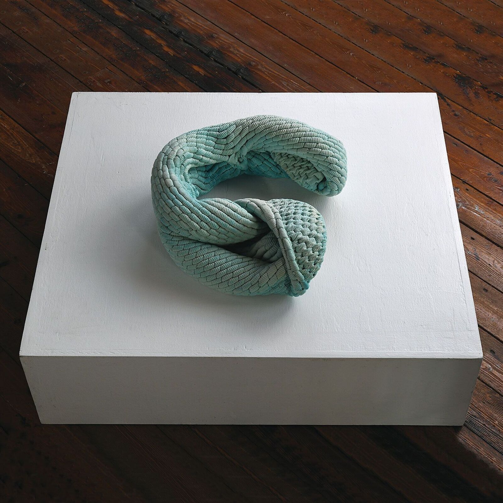 A white box with a green knot on top of it.