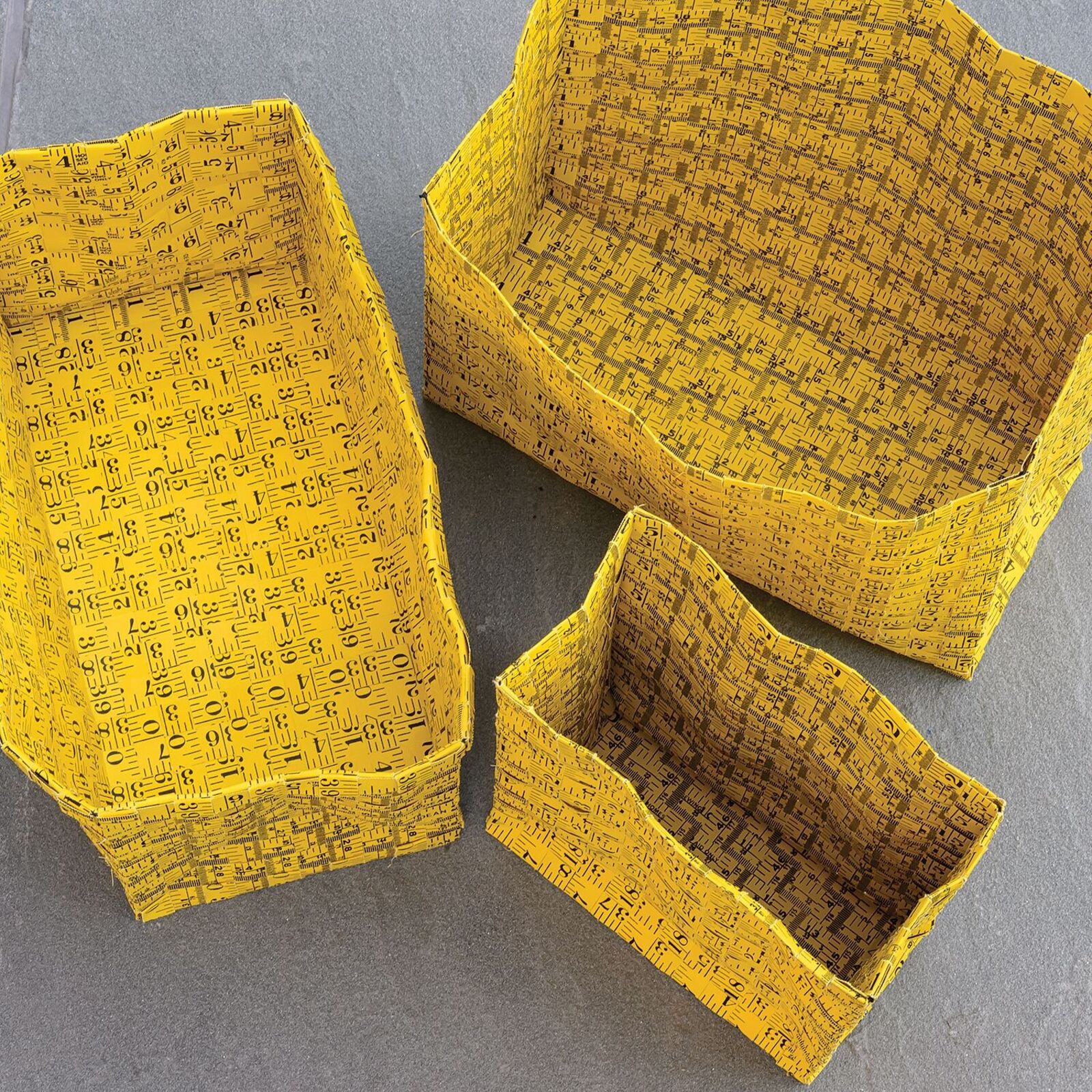 A yellow gift bag with a black geometric pattern sits on a dark table.