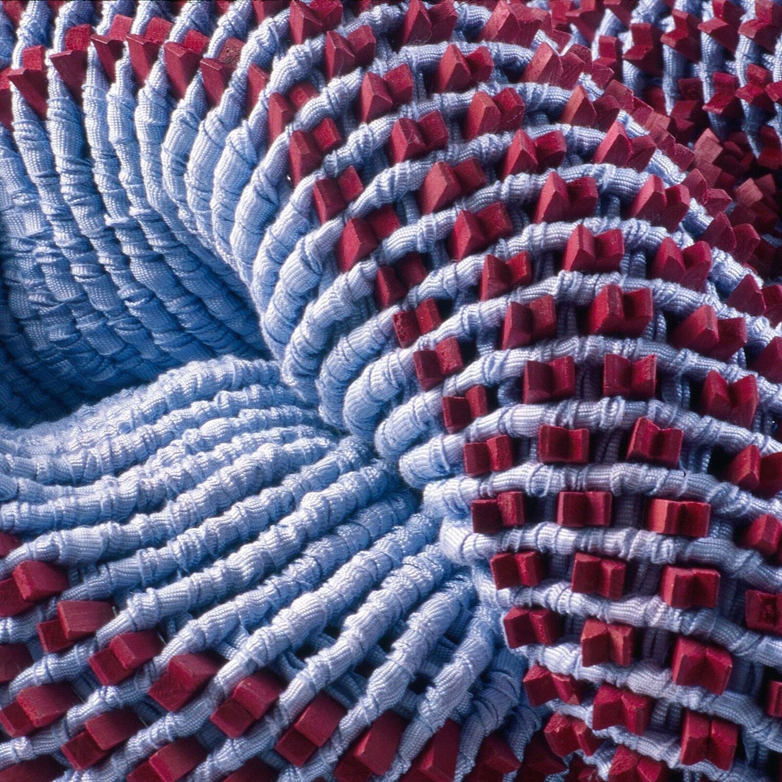 A red and blue knitted object on a white surface.