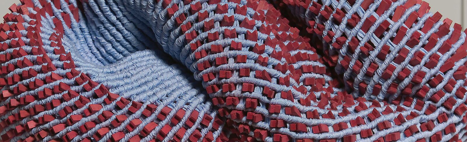 A red and blue knitted object on a white surface.