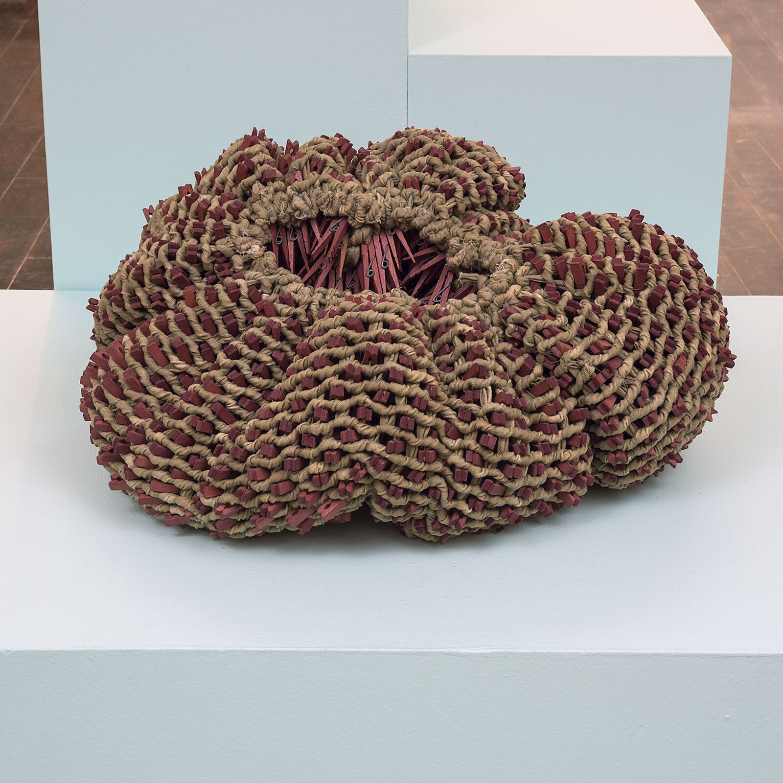 A sculpture on a white pedestal in a room.