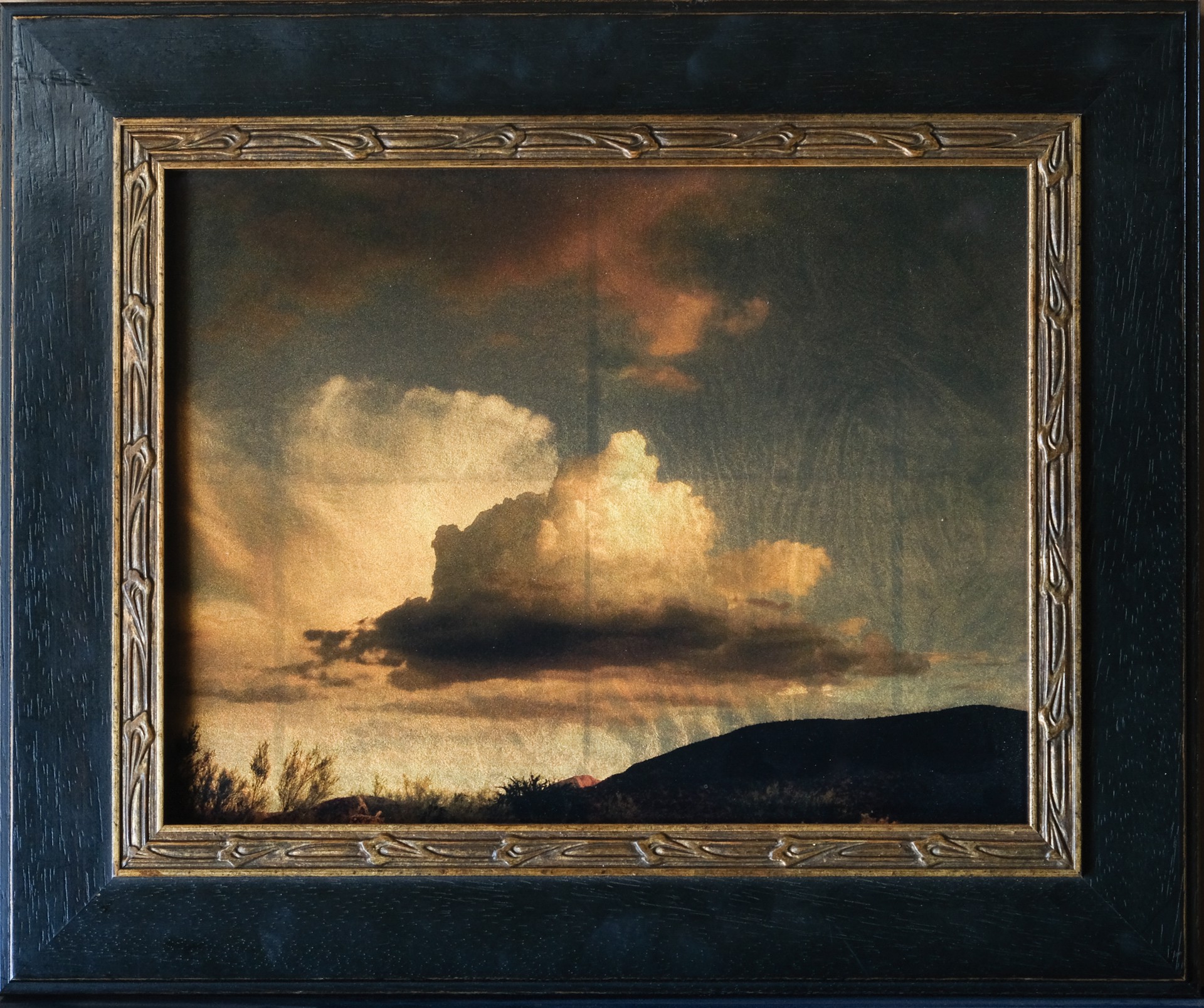 A dramatic landscape painting featuring a massive cloud formation over a dark hill.