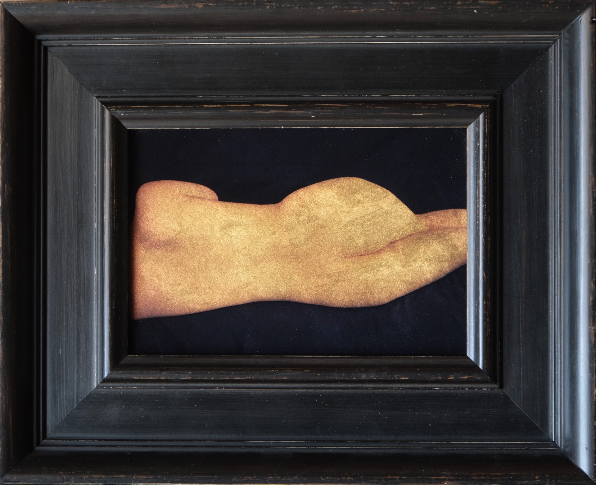 A painting of a hand in a black frame.