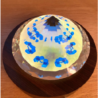 A crystal ball with blue flowers on it sitting on a table.