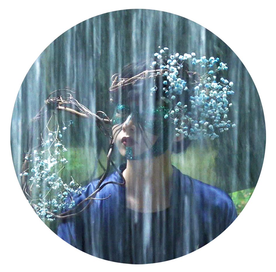 A woman with a wreath of flowers on her head in the rain.