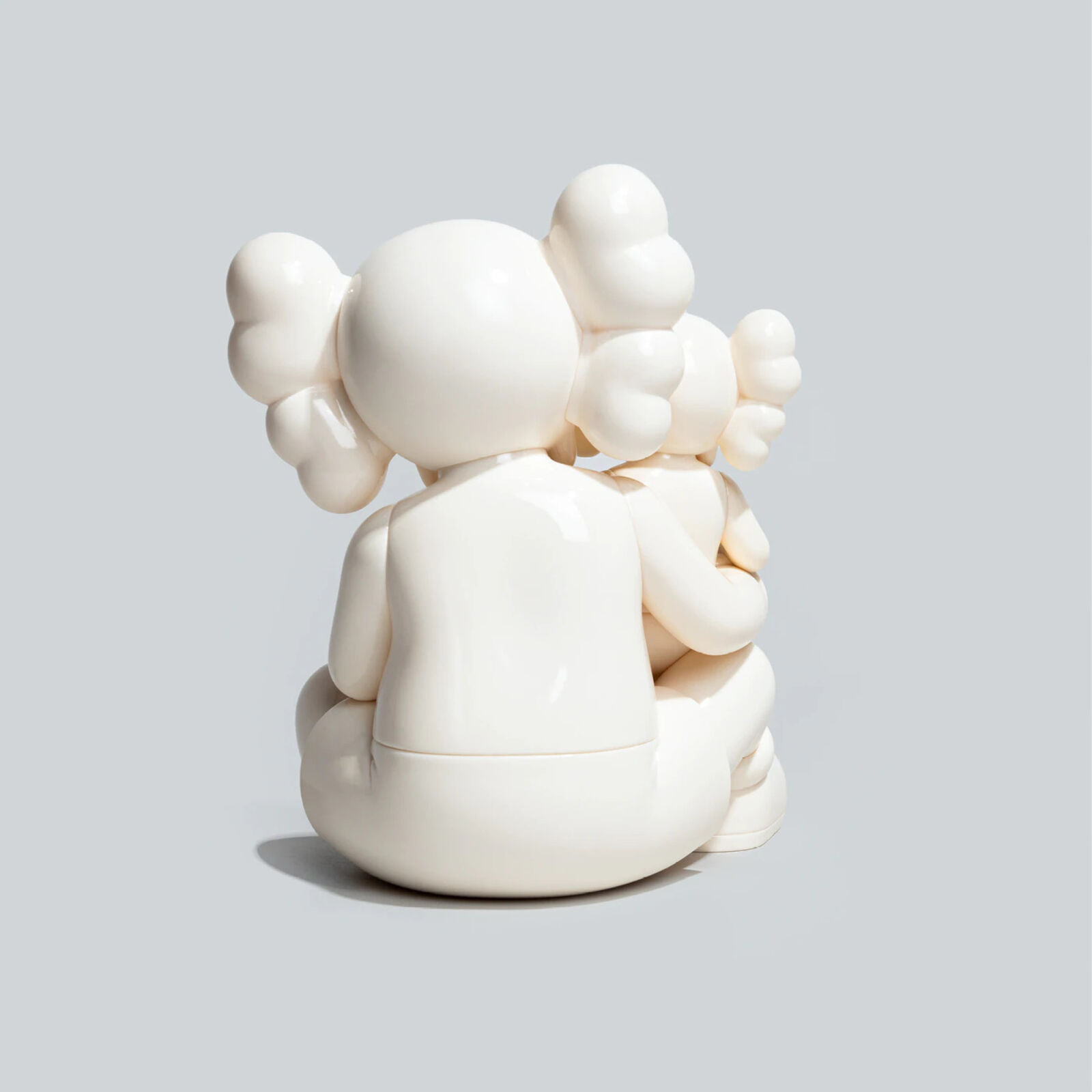 A couple of white figurines sitting on top of each other.