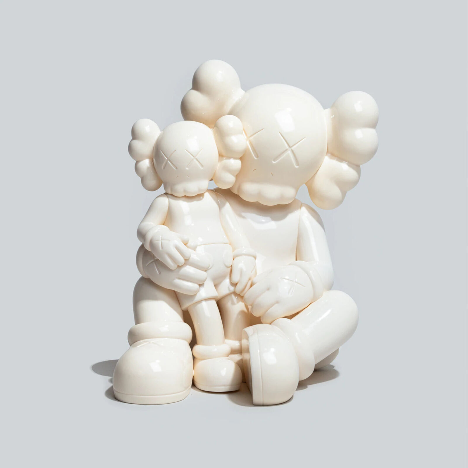 A couple of white figurines sitting on top of each other.