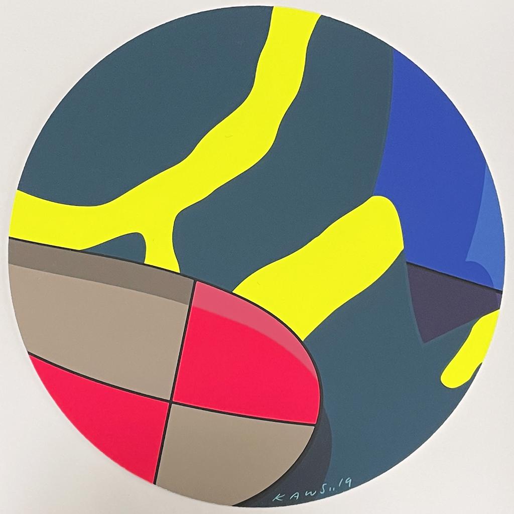 A painting on a white wall with a blue, yellow, red, and gray circle.