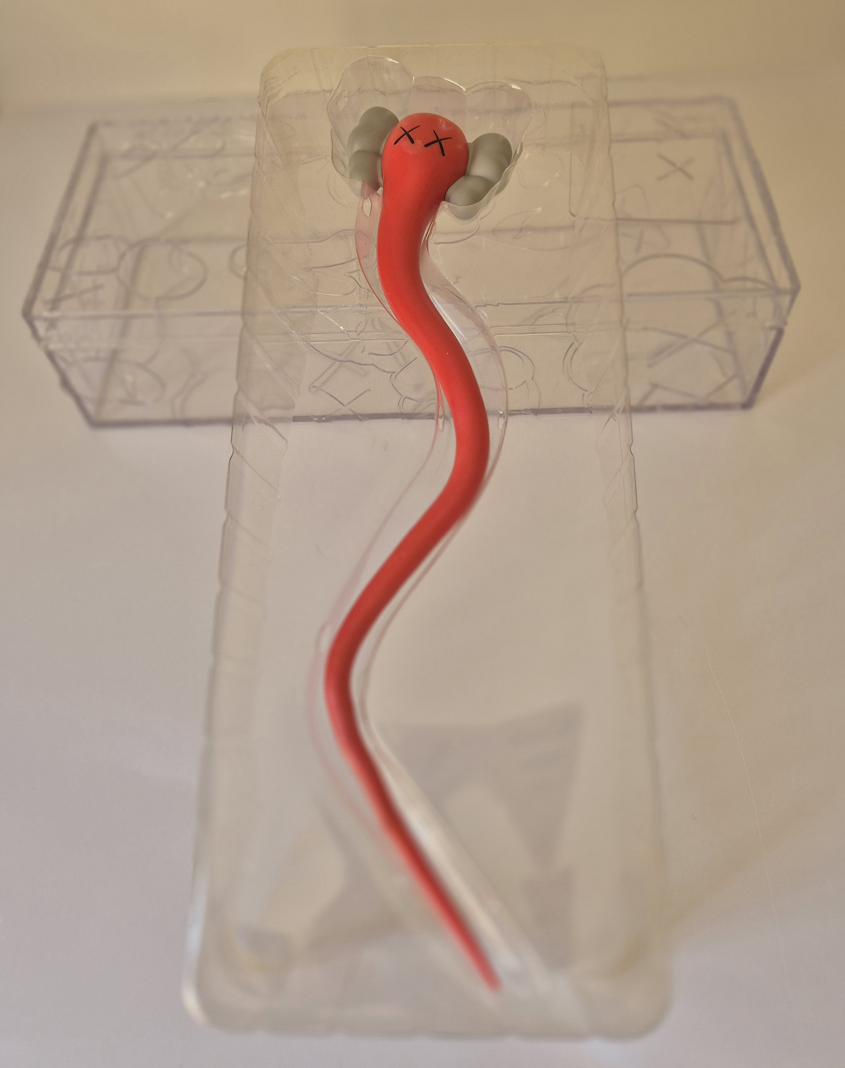 A pair of red and gray earbuds in a clear plastic case.
