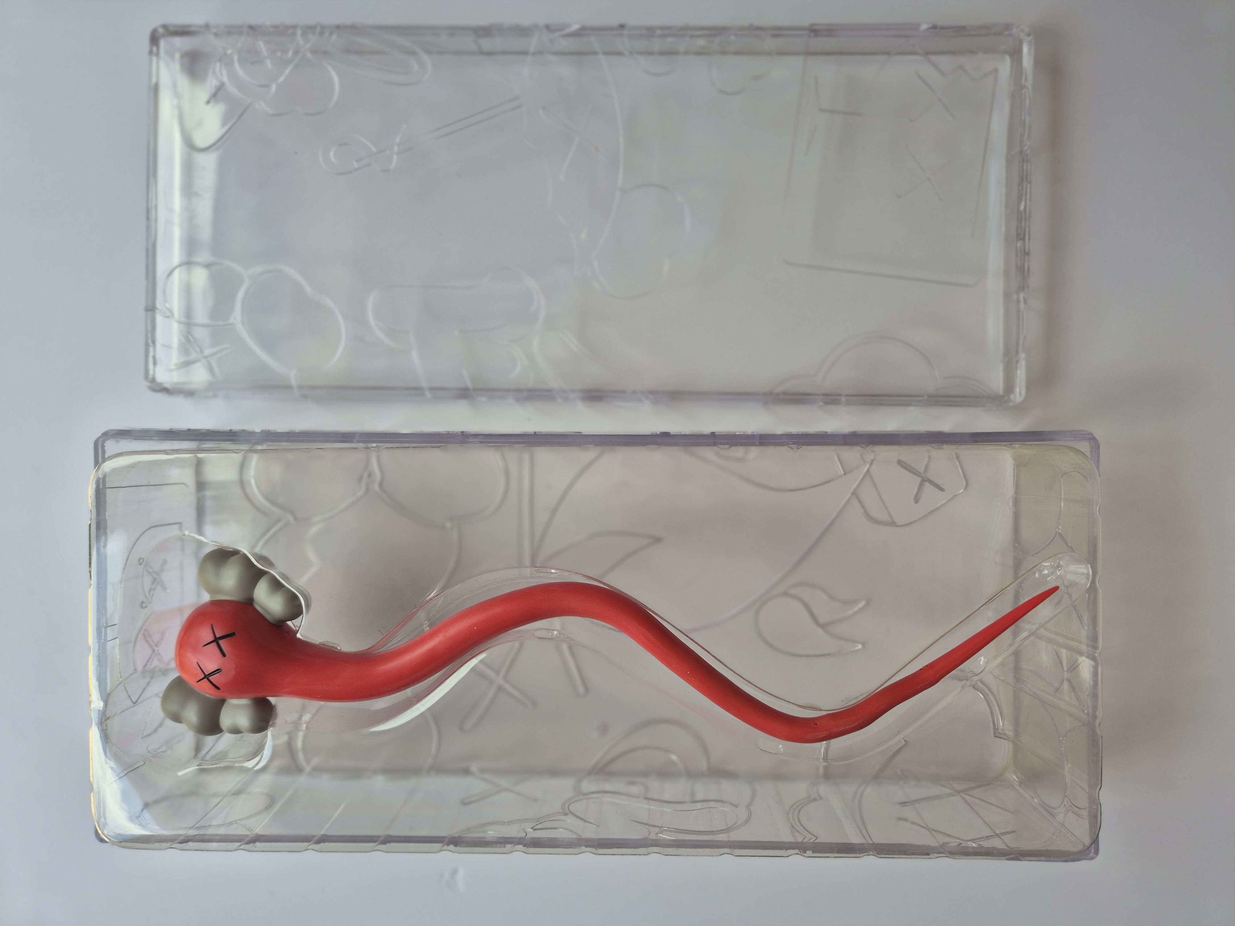 A pair of red and gray earbuds in a clear plastic case.