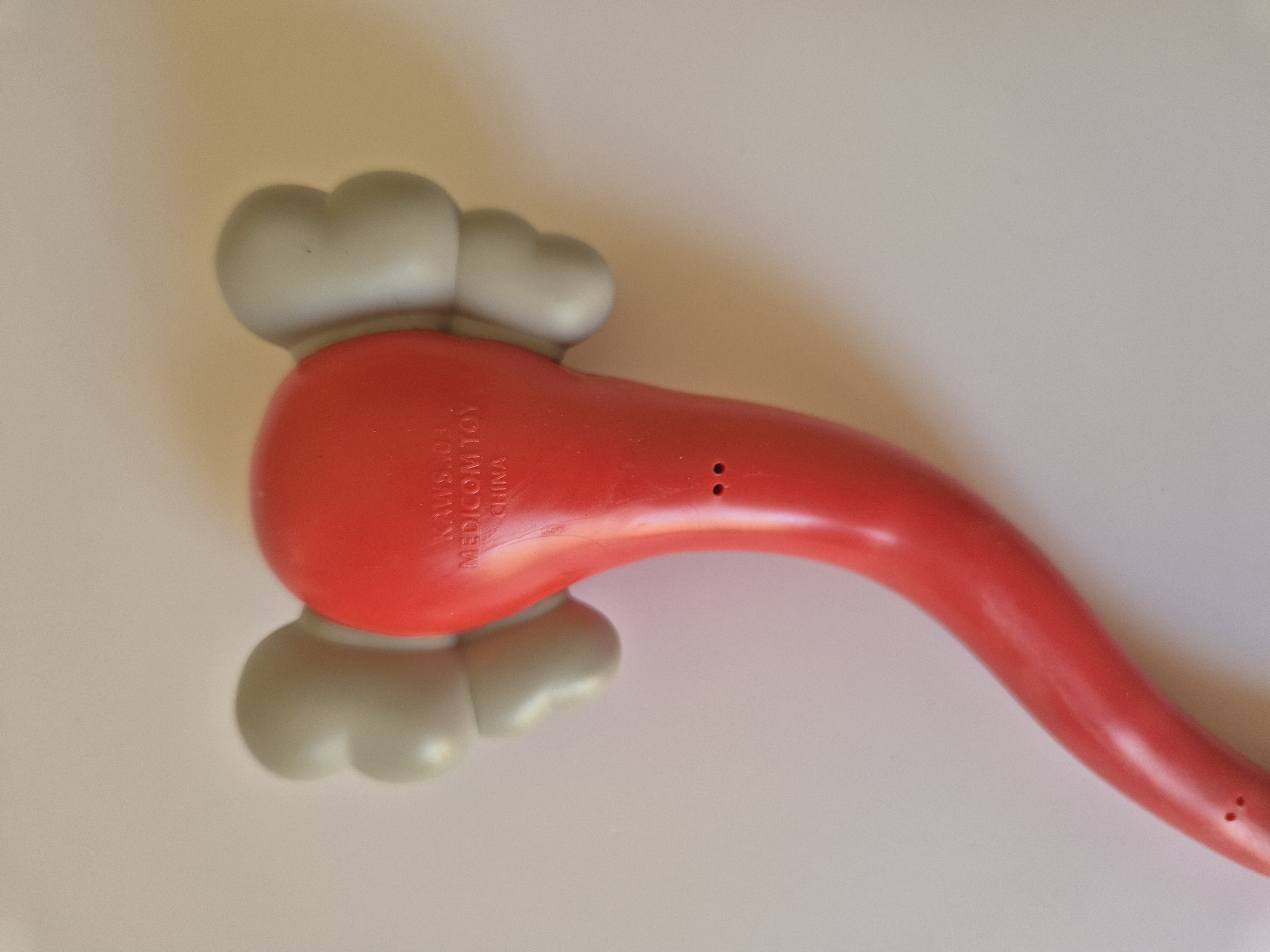 A pair of red and gray earbuds in a clear plastic case.