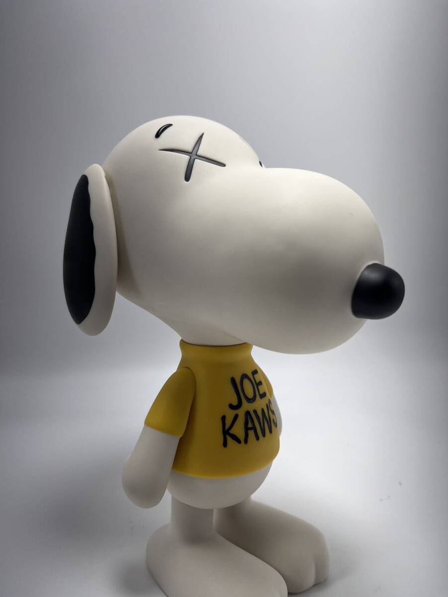 A stylized white dog figure wearing oversized sunglasses and a yellow shirt with black text.