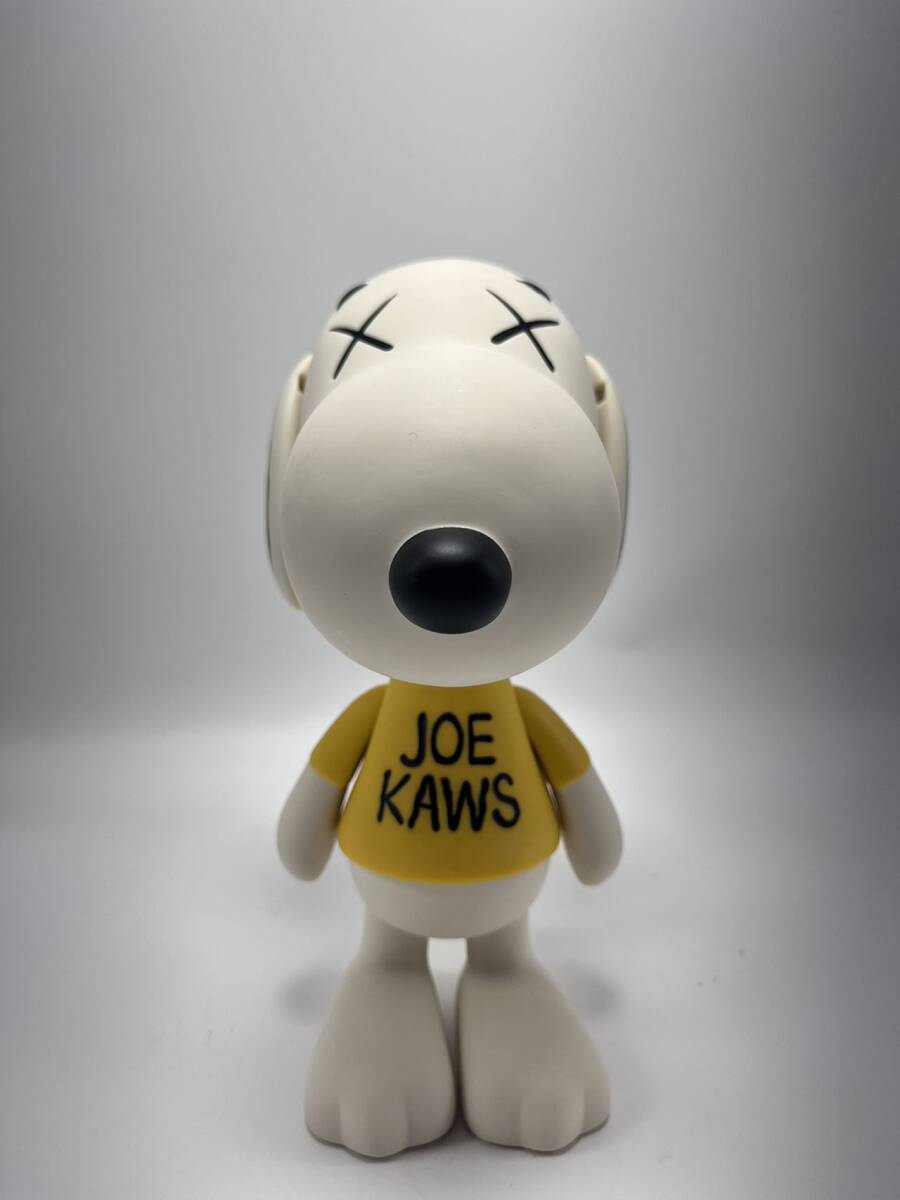A stylized white dog figure wearing oversized sunglasses and a yellow shirt with black text.