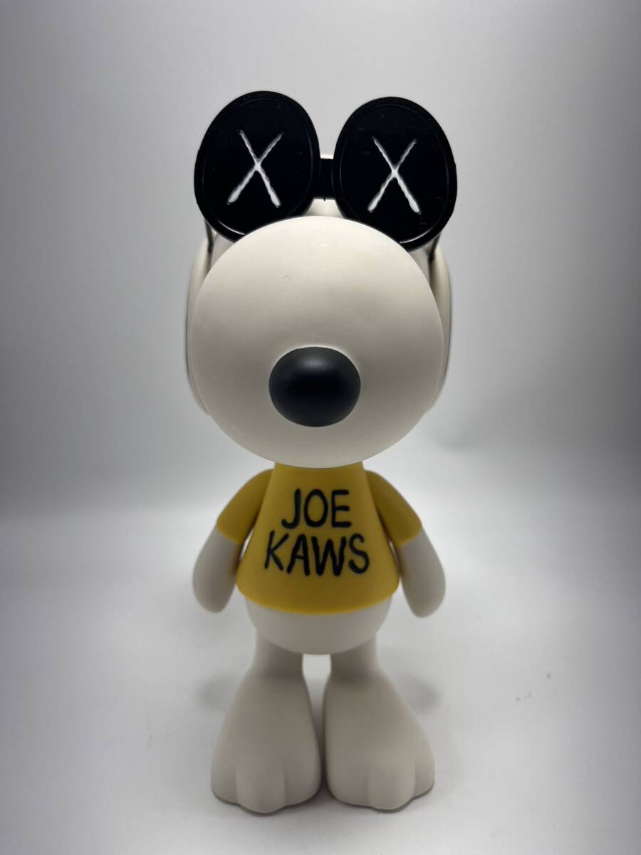 A stylized white dog figure wearing oversized sunglasses and a yellow shirt with black text.
