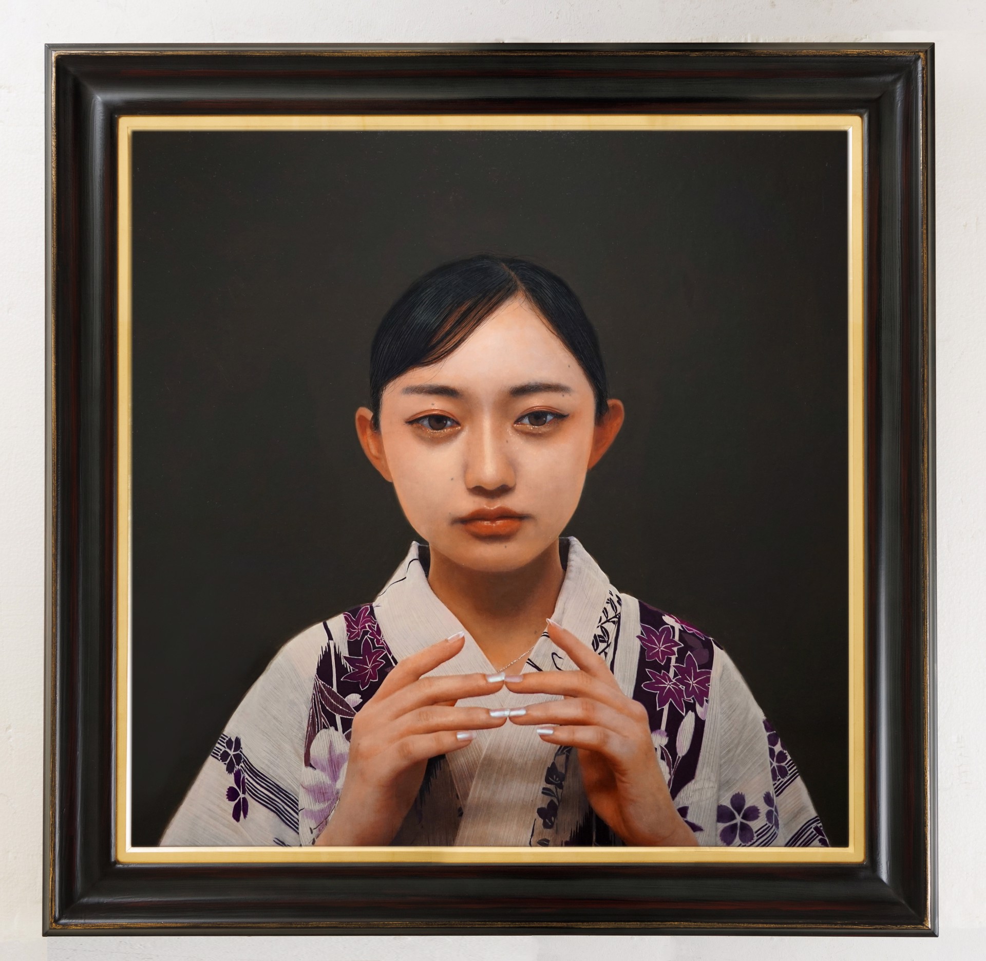 A painting of a woman in a kimono holding her hands together.