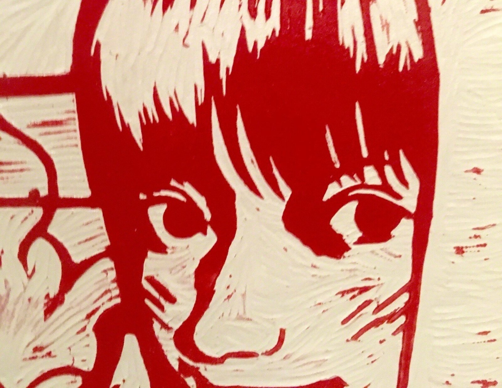 A red and white graphic print on three stacked skateboard decks displayed on a wooden stand.
