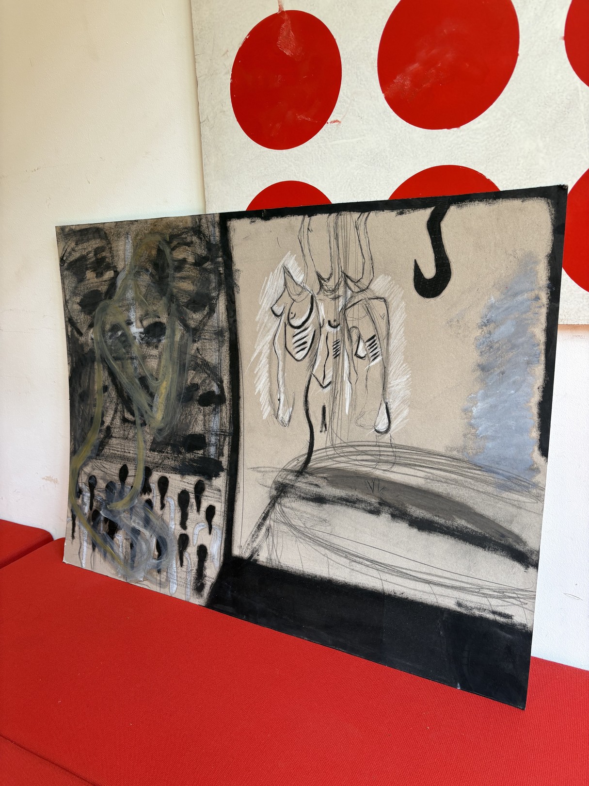 A split-panel artwork featuring abstract figures against a red polka-dot backdrop.