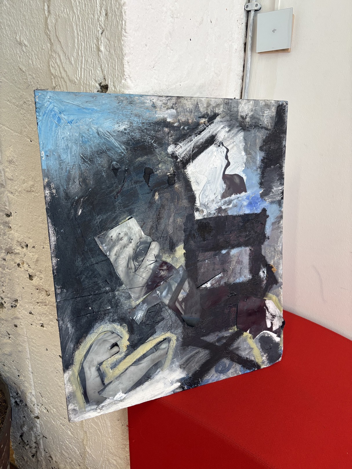 An abstract expressionist oil painting on canvas featuring a figure in shadow against a red surface.