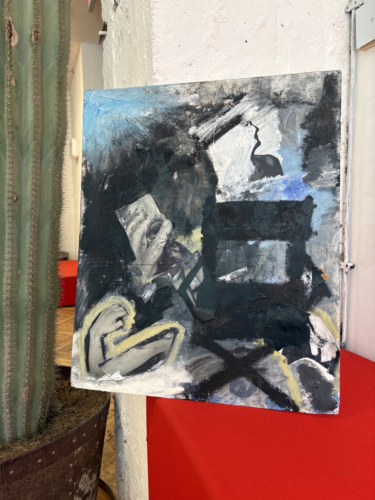 An abstract expressionist oil painting on canvas featuring a figure in shadow against a red surface.