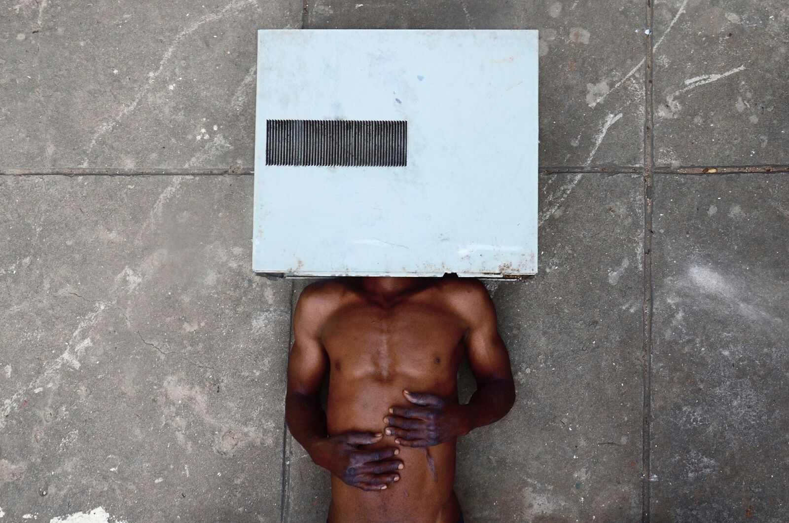 A man with a box on his head on the ground.