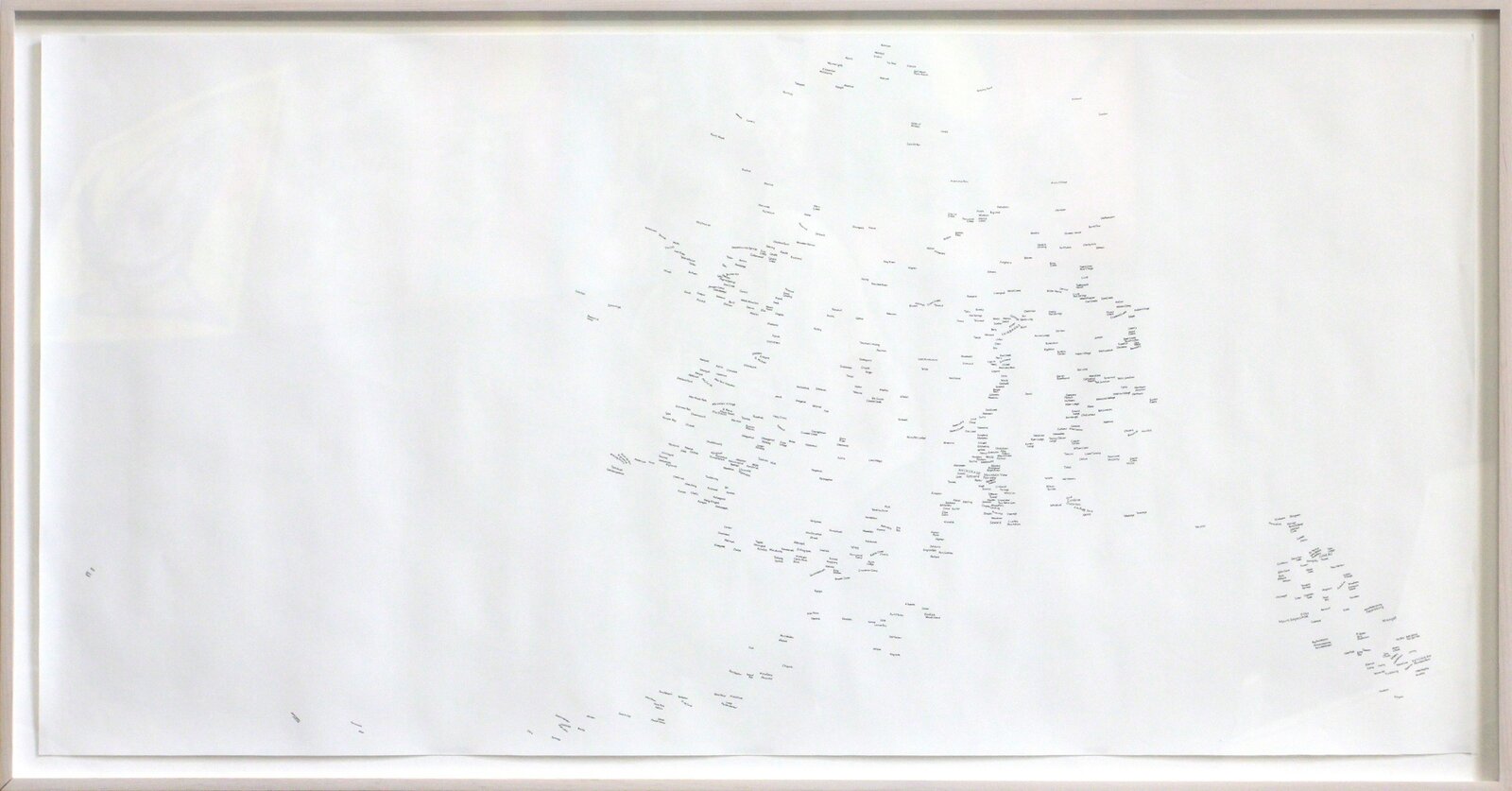 A minimalist framed artwork featuring a sparse arrangement of tiny black text fragments on a white background.