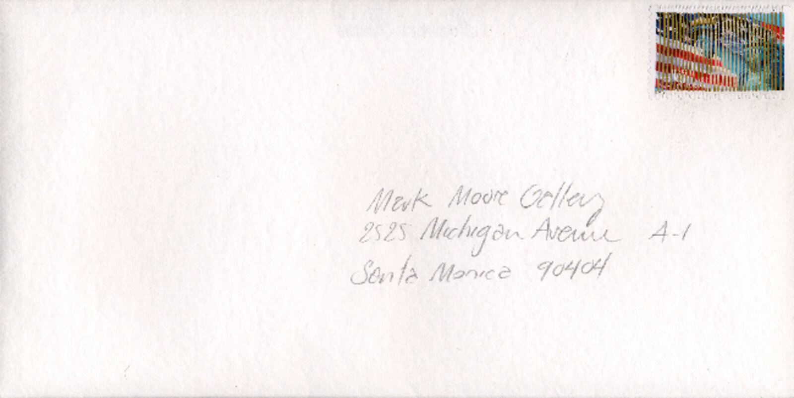 A white envelope with a colorful postage stamp and handwritten address.