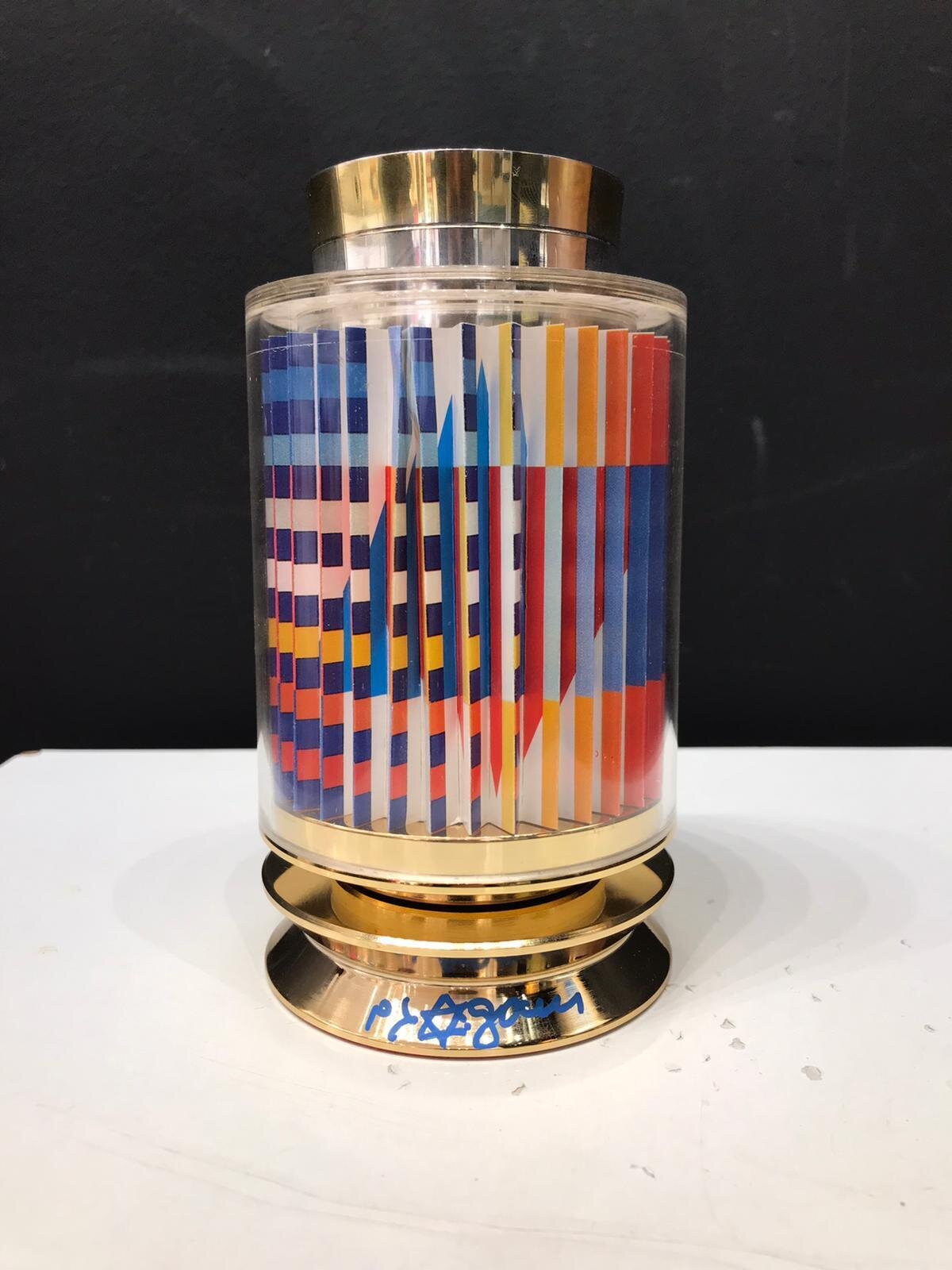 A geometric glass sculpture with a colorful internal pattern and metallic accents.