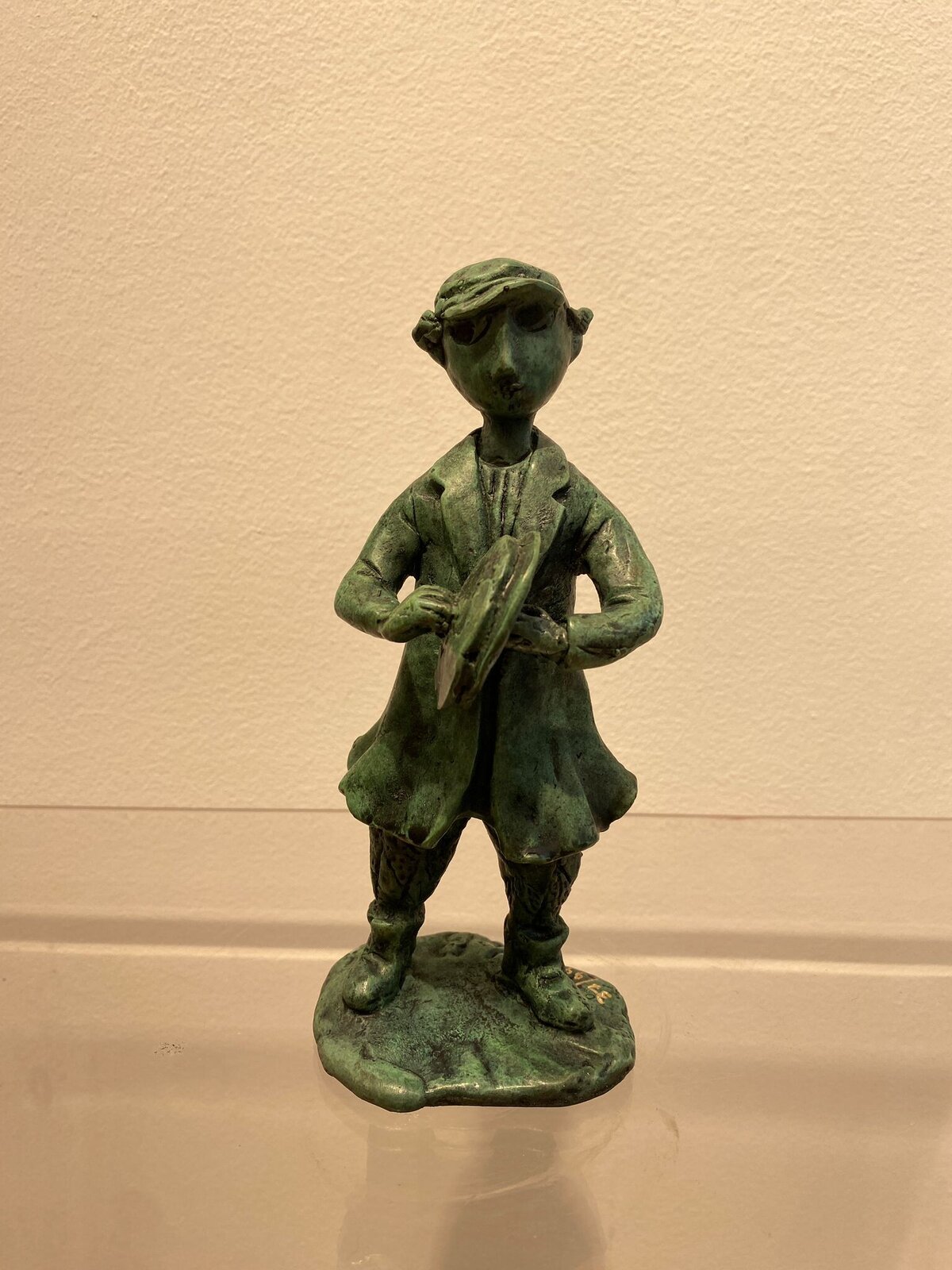 A small bronze sculpture of a painter figure holding an easel.