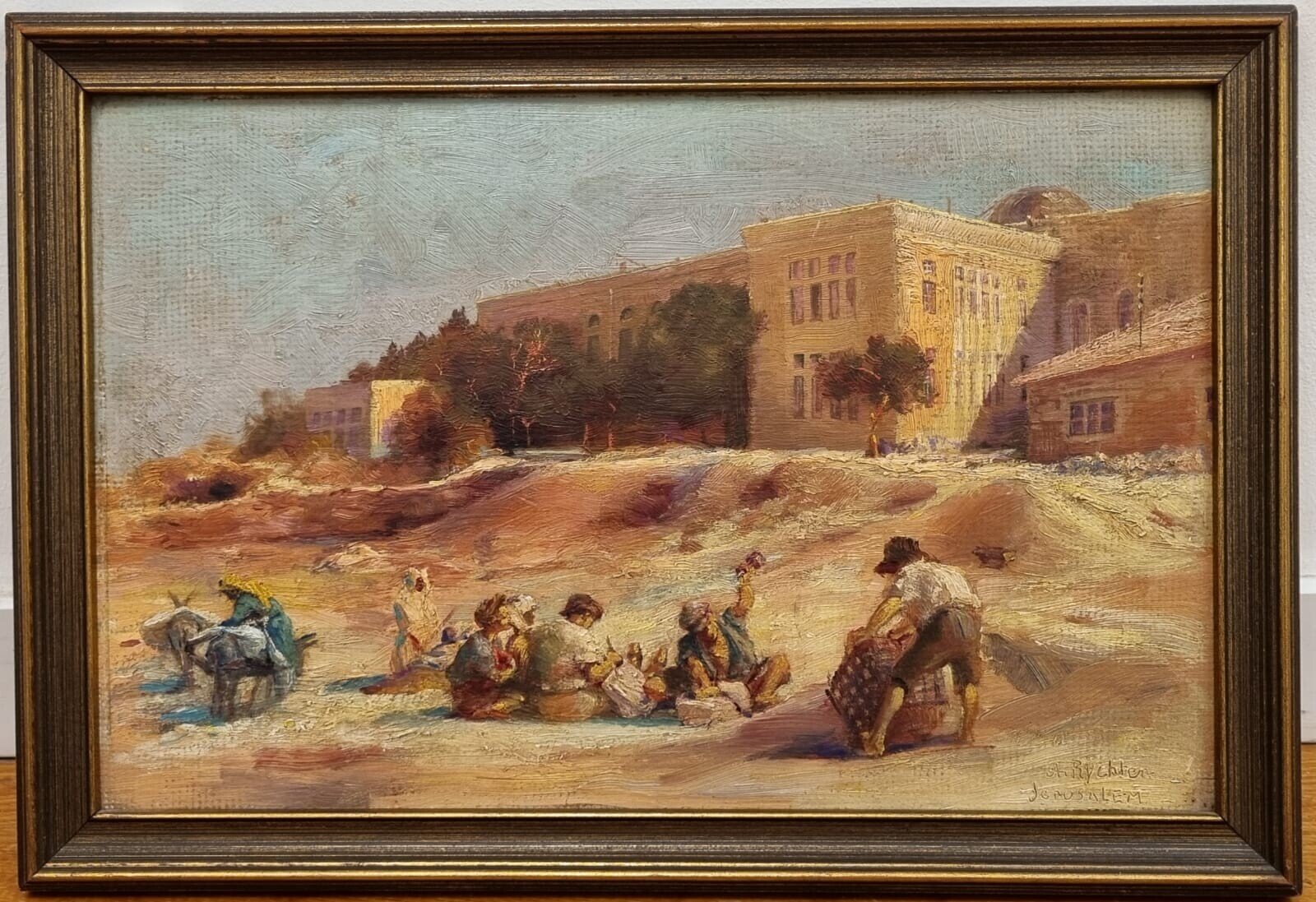 A sun-drenched street scene with figures resting near a large building.
