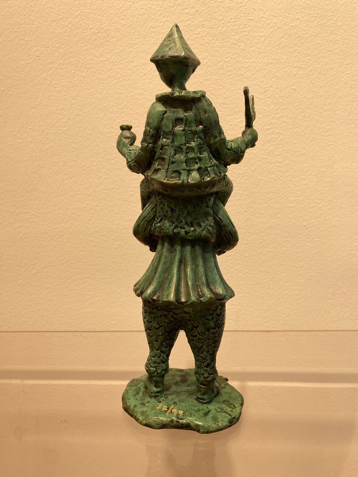 A small bronze sculpture of a painter figure holding an easel.